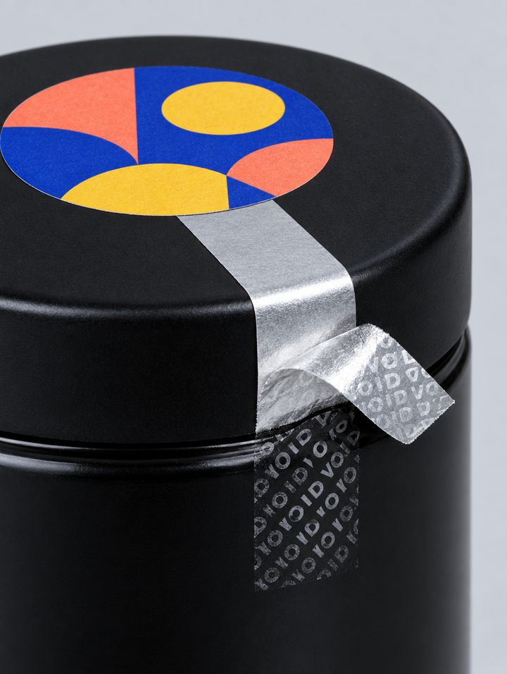 A silver tamper-evident strip peeled back from a jar lid, leaving a VOID pattern.